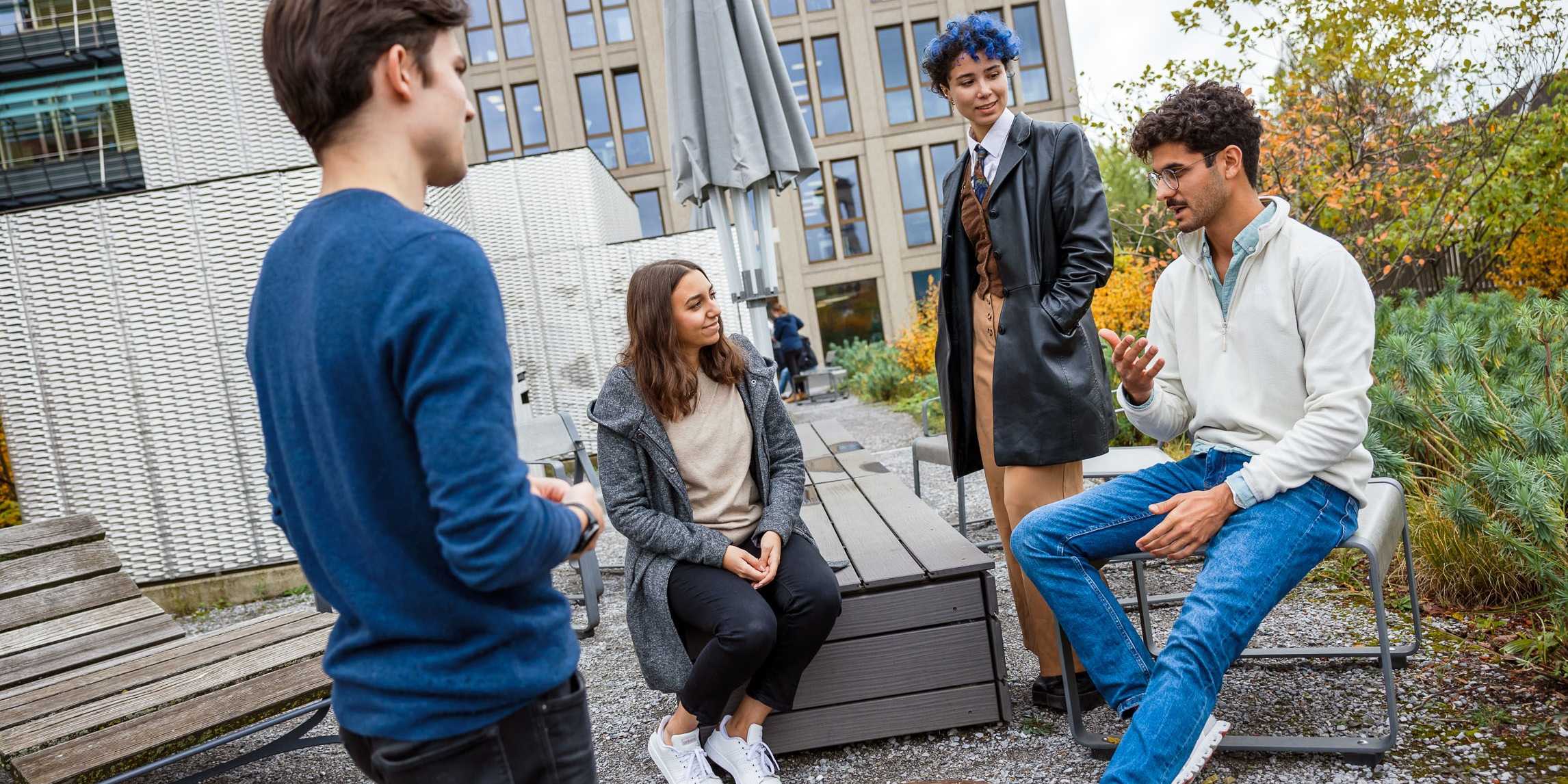 Weibliche und männliche Studierende im entspannten Gespräch auf der Dachterrasse des LEE-Gebäudes