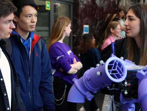 Vergrösserte Ansicht: Studentin erklärt zwei Besuchern die Drohne