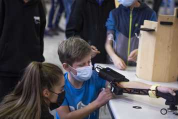 Vergrösserte Ansicht: Ein Junge arbeitet an einem Roboter-Arm