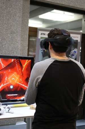 Man with VR goggles in front of a screen
