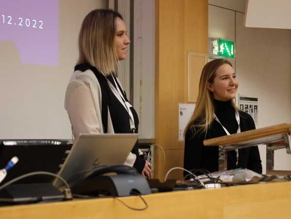 Damla Welti and Michèle Strzelecki stand at the front desk in the lecture hall