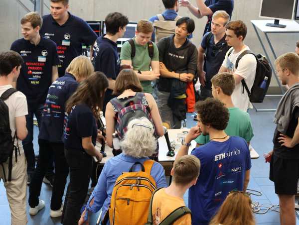 Enlarged view: Numerous visitors crowd around the booth with the robot magnecko