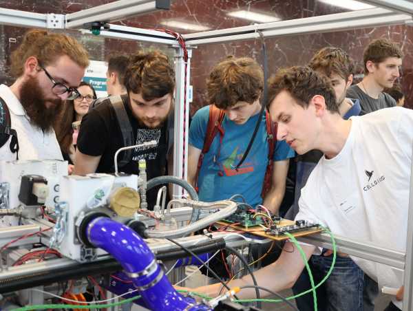 Enlarged view: Student shows three visitors technical details of the machine