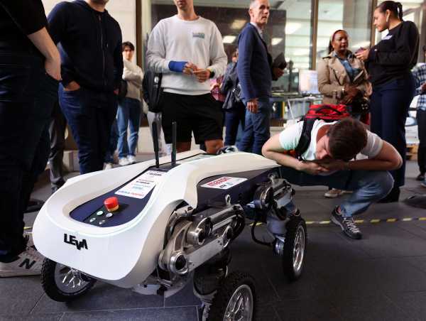 Enlarged view: Visitors marvel at the four-wheeled transport robot