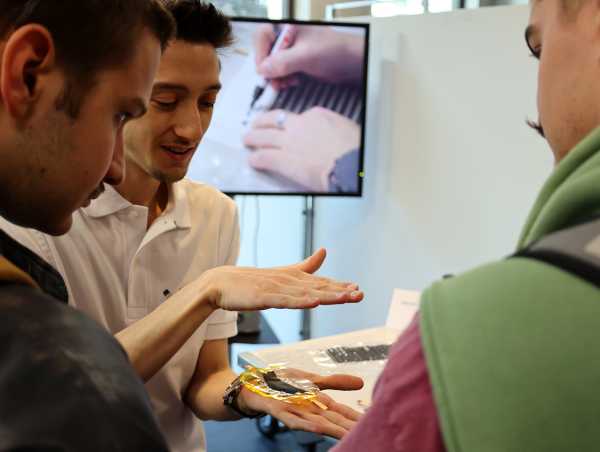 Enlarged view: Student explains artificial muscles to guests