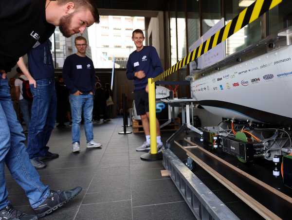 Enlarged view: Visitors bend down to better see how the pod glides over the rail