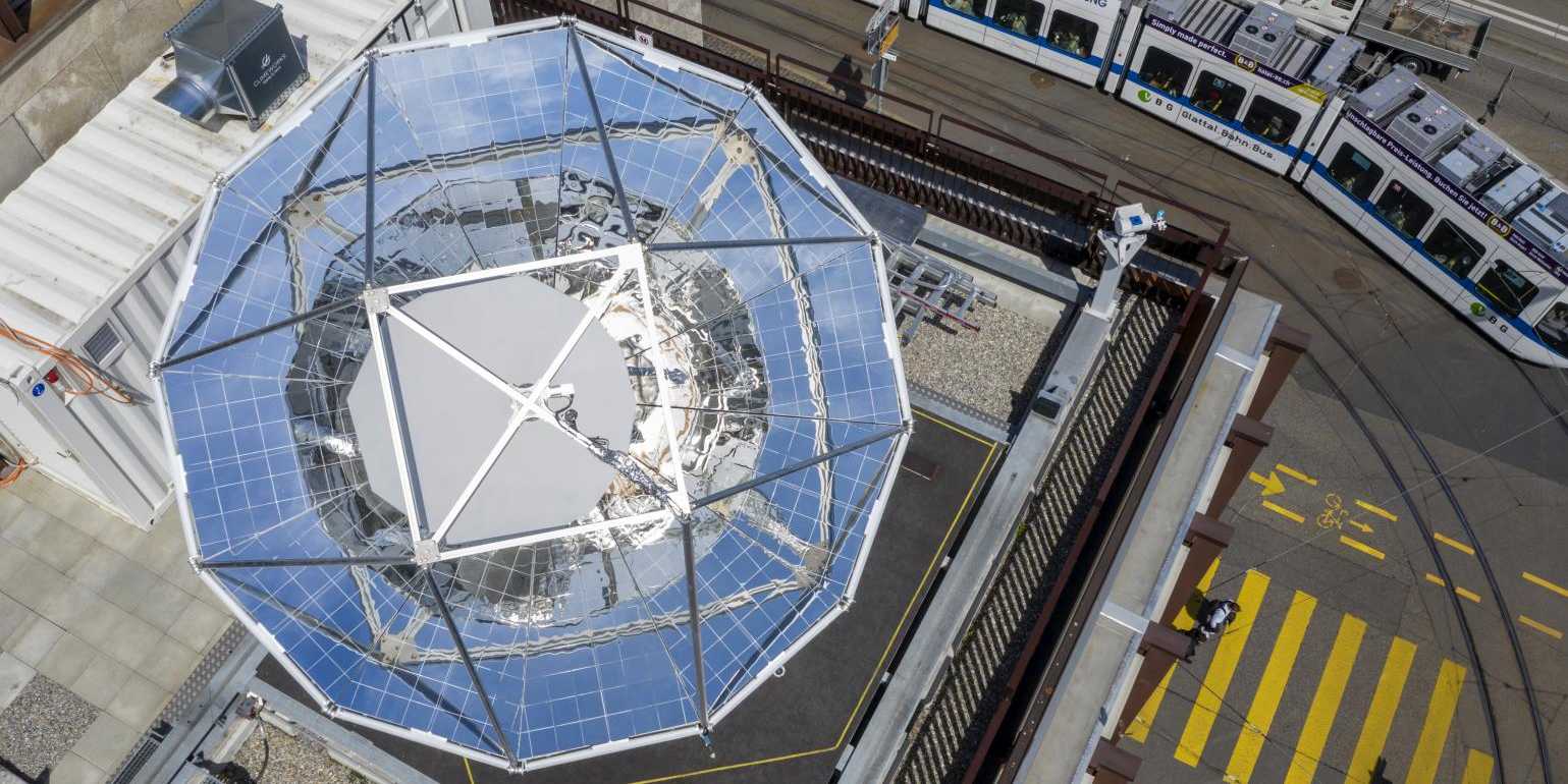 Parabolic reflector from bird perspective on the rooftop of ML building in ETH Zentrum. In the street, a tram can be seen.